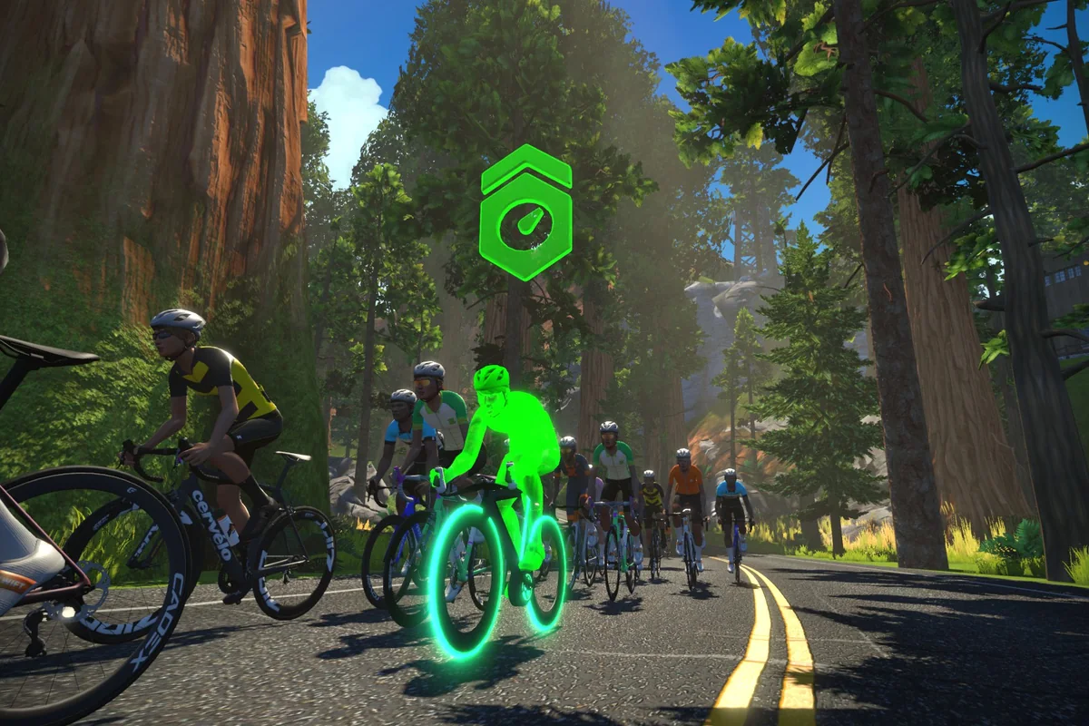 Zwift riders following a green-glowing RoboPacer through a forest route