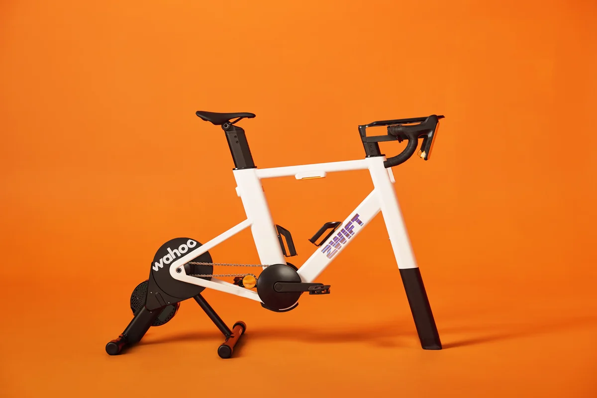 Zwift Ride smart frame mounted on Wahoo KICKR Core 2 trainer against an orange background